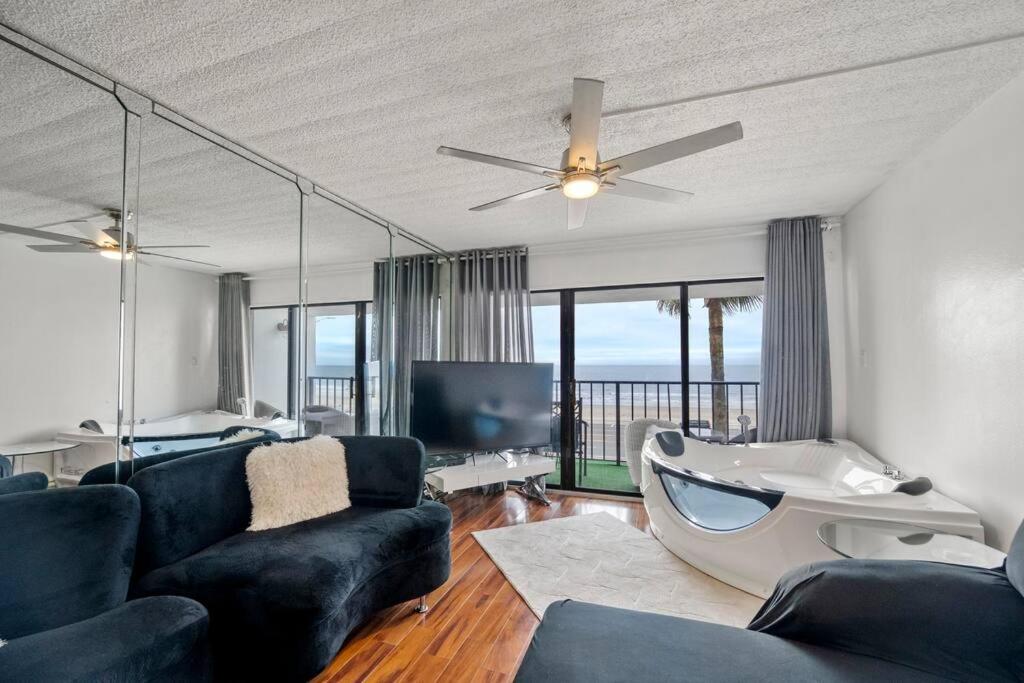a living room with a couch and a ceiling fan at Bello condominio con vista al mar, jacuzzi interno in Galveston