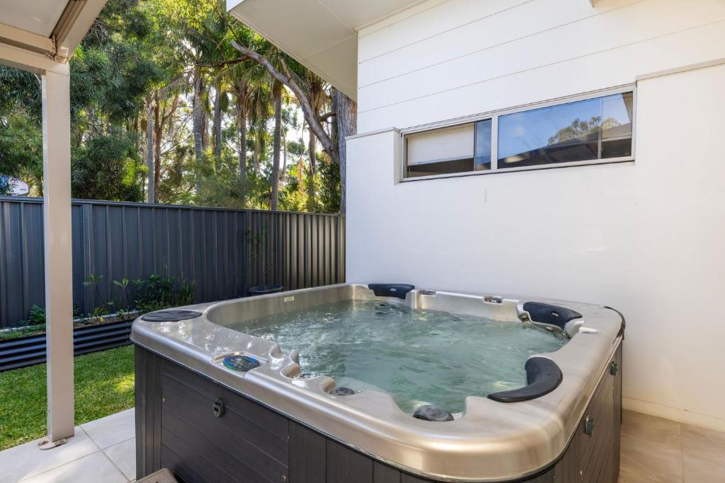 a jacuzzi tub in the backyard of a house at Bay Gem - Pet Friendly with Spa in Callala Bay