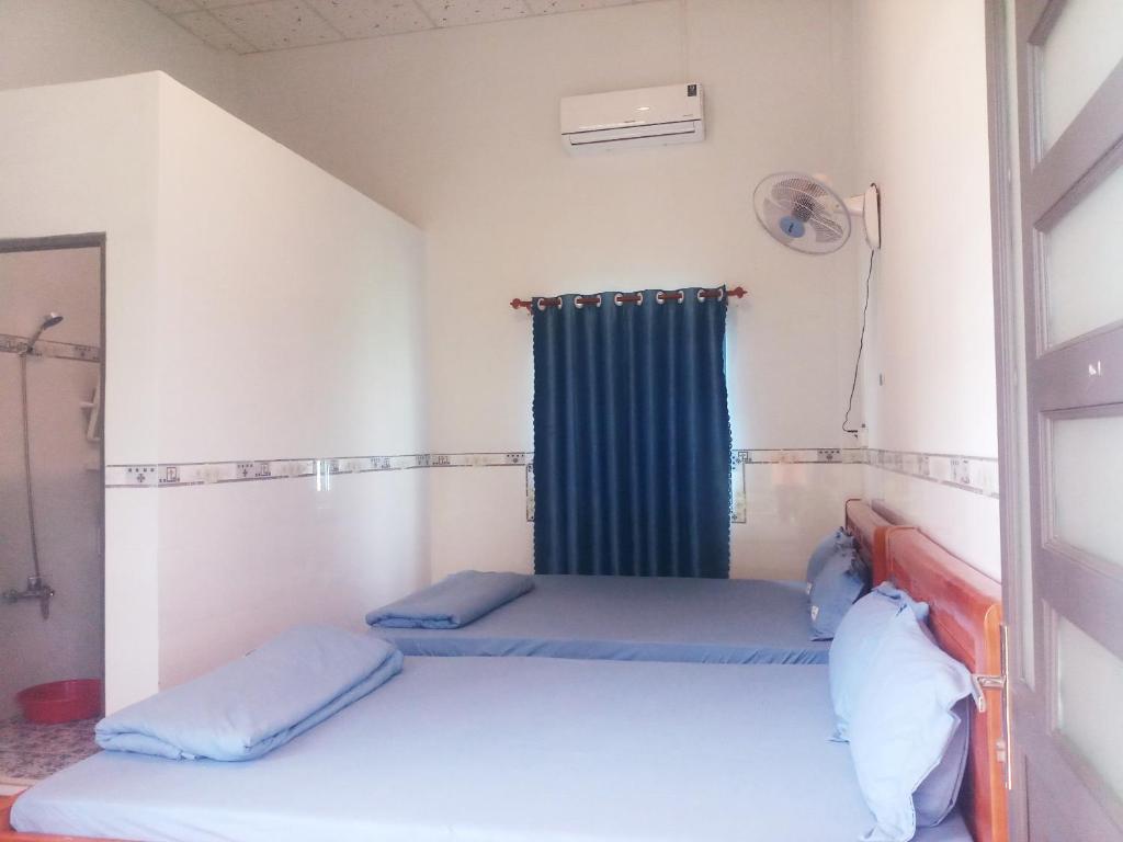 a room with two beds and a window at Đức Phát Homestay in Tân Phú