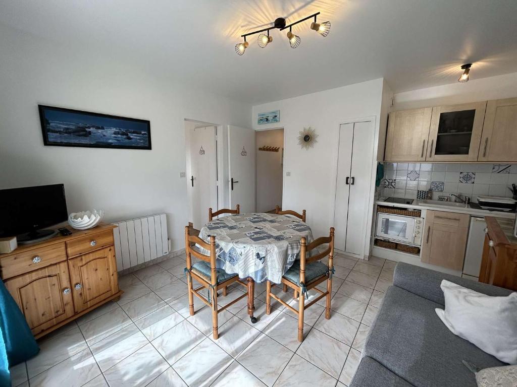 une cuisine avec une table et des chaises dans une pièce dans l'établissement Appartement 2 pièces, 5 couchages, parking privé, proche plage et commerces, Saint-Hilaire-de-Riez - FR-1-224C-287, à Saint-Hilaire-de-Riez