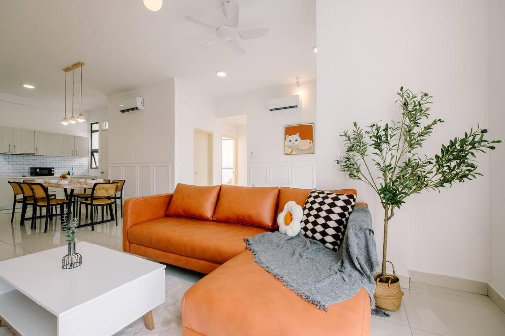 een woonkamer met een oranje bank en een tafel bij Shamelin Star Spacious Home 8pax3BR InfinityPool 中文 in Kuala Lumpur