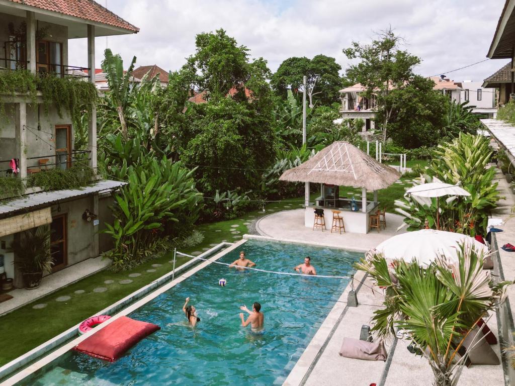 a group of people in the swimming pool at a resort at Sepeda Hostel in Canggu