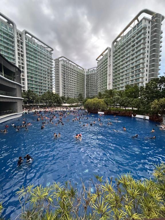 a group of people swimming in a large swimming pool at Azure Staycation Place in Manila