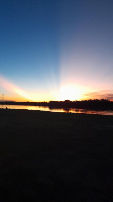 a sunset over a field with a body of water at Villa Florida in Villa Florida