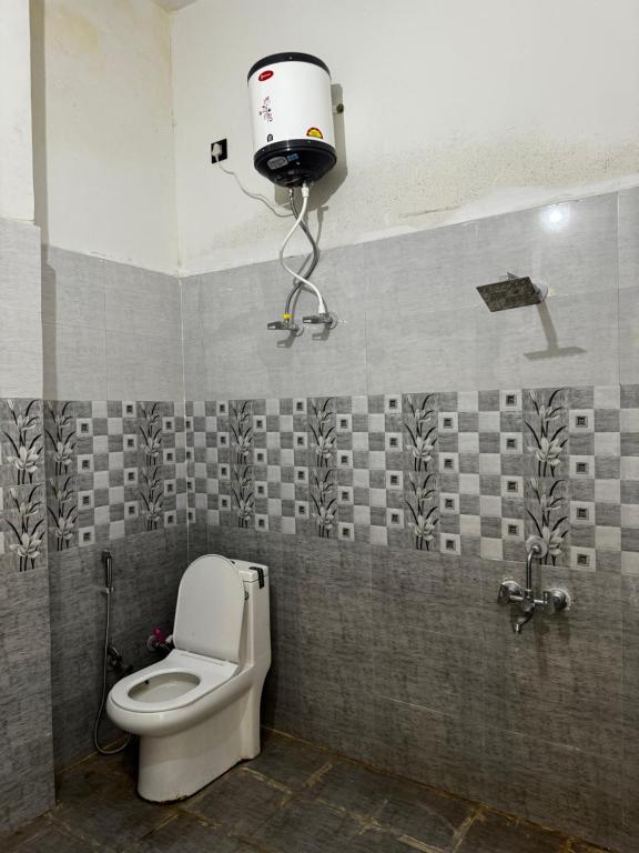 La salle de bains est pourvue de toilettes et d'une caméra murale. dans l'établissement Akash home stay, à Mussoorie