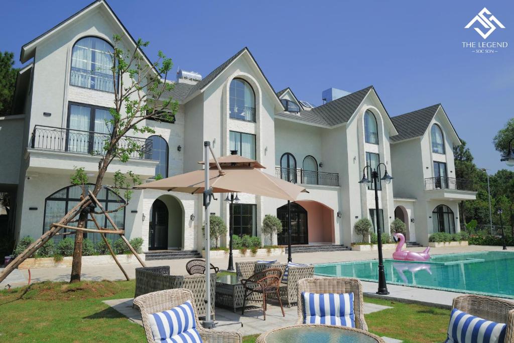 een groot huis met een zwembad en een huis bij Villa The Legend Soc Son in Hanoi