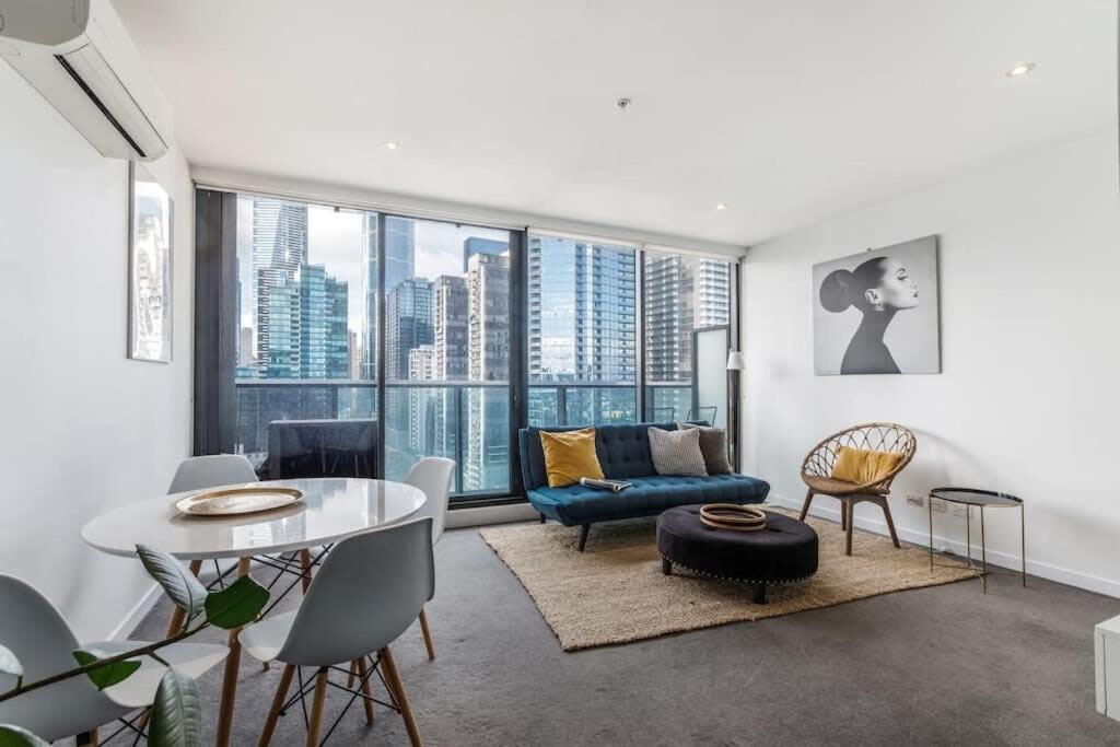 sala de estar con sofá azul y mesa en Southbank Bella - New Listing, en Melbourne