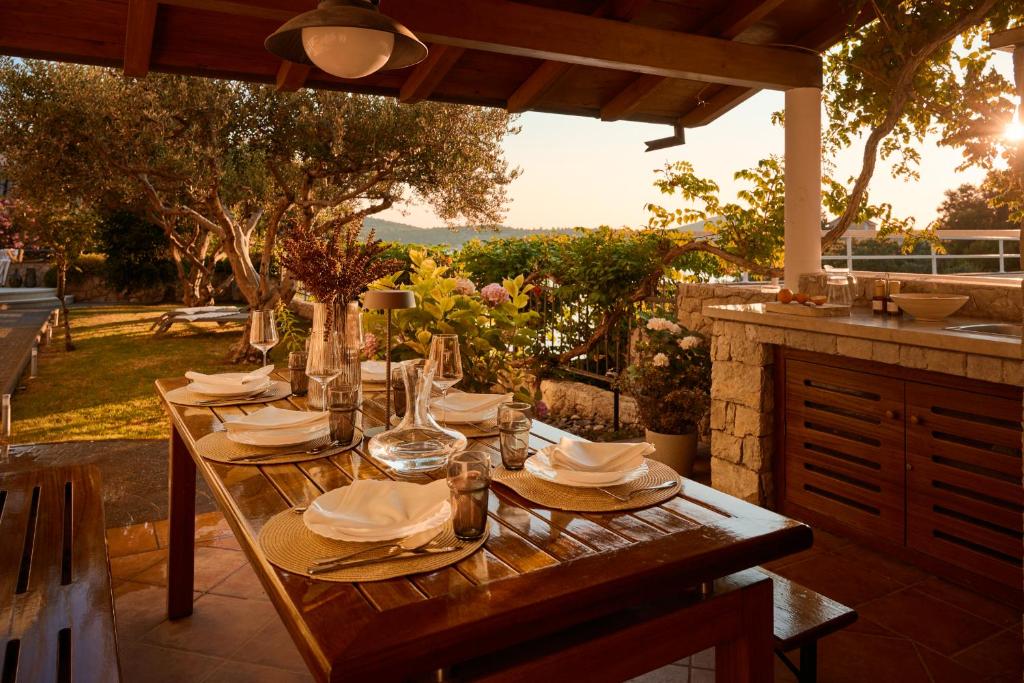 una mesa de madera con platos y servilletas en el patio en Luxurious city retreat with pool, en Šibenik