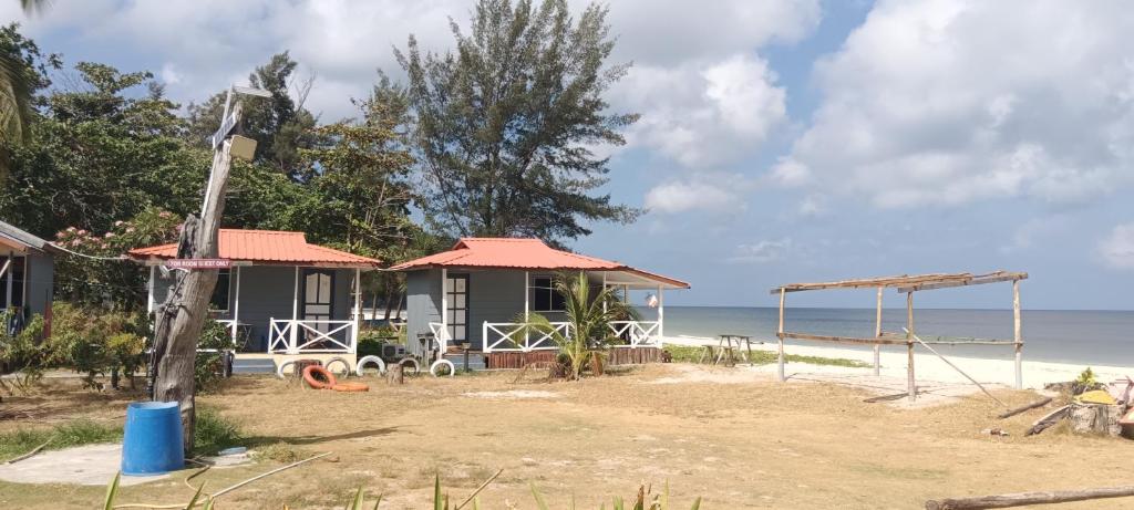 una casa en la playa con el océano en el fondo en Tumombuvoi homestay, en Tiga Papan