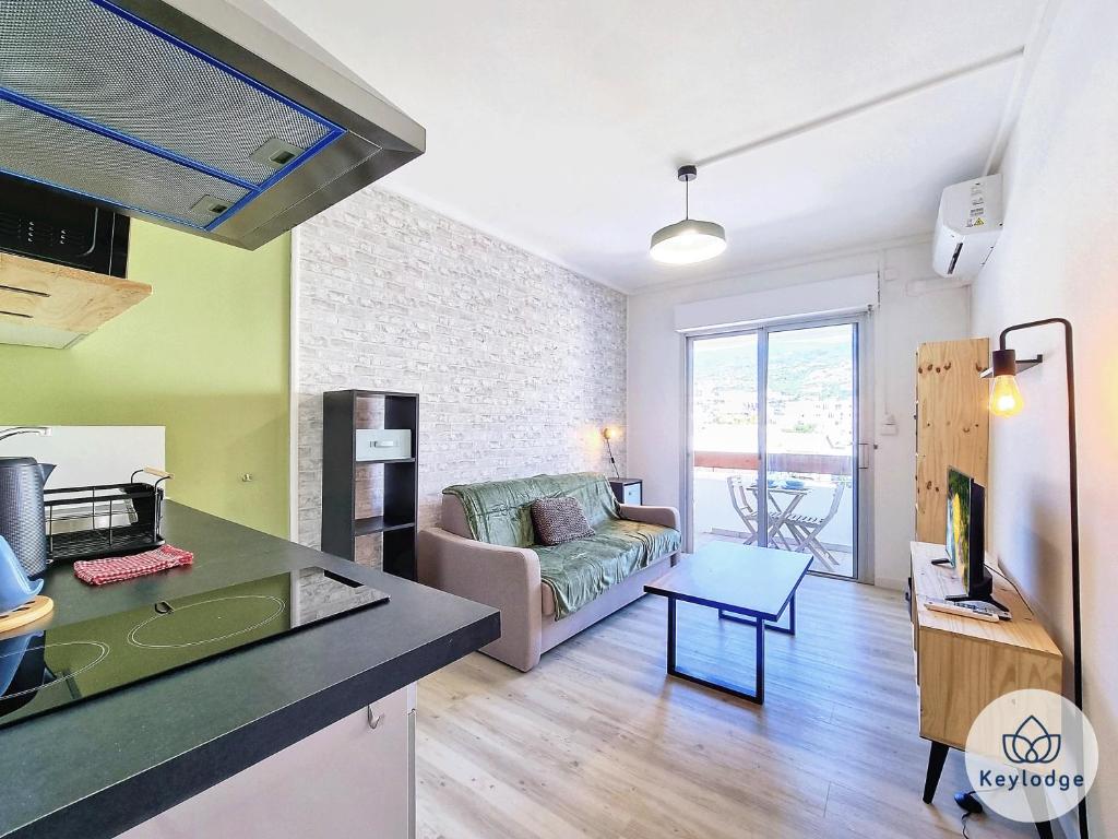 a kitchen and a living room with a couch at Ti Studio Créole 2 - proche du centre ville - 21m² - Saint-Denis in Saint-Denis