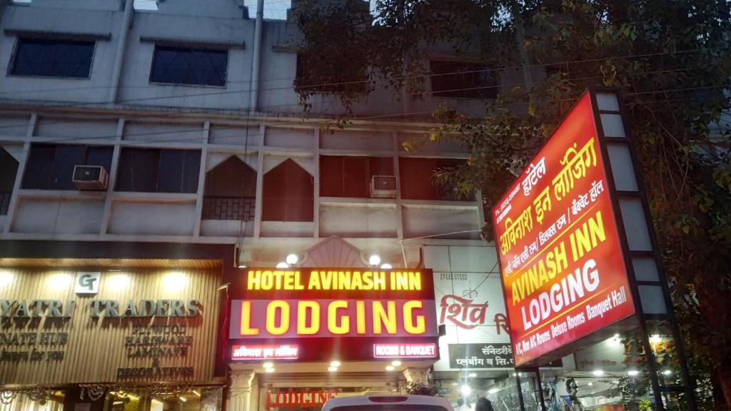 a building with neon signs in front of it at Hotel Avinash Inn Lodging in Nashik