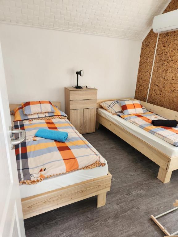 2 camas individuales en una habitación con 3 camas individuales que establece que en Nagyi Apartman Kecskemét, en Kecskemét