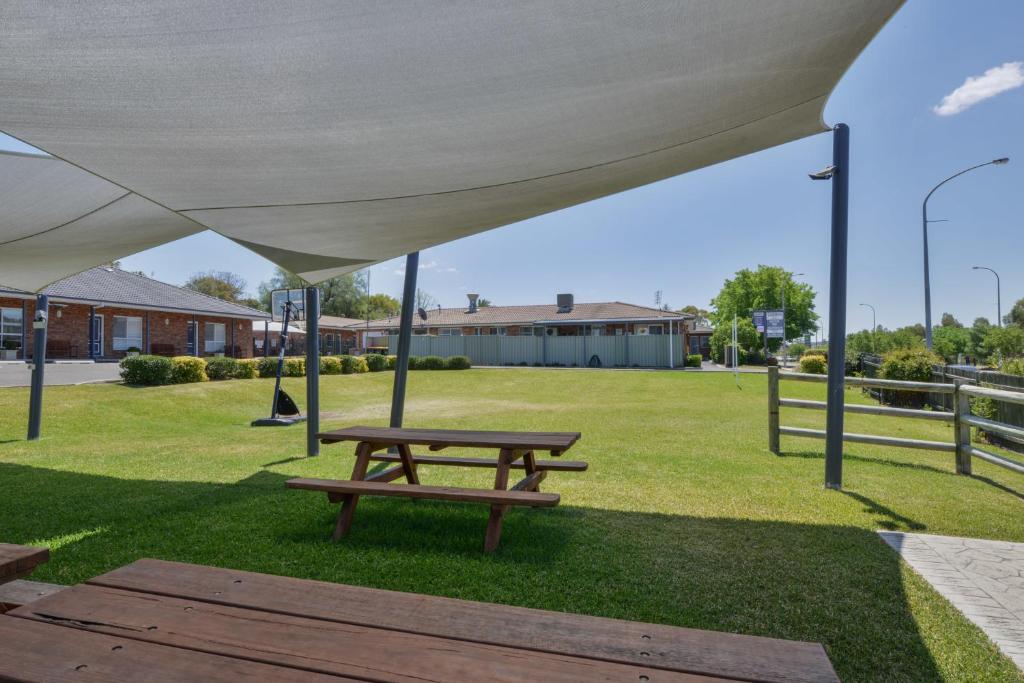 a picnic table under a tent in a park at Cadman Motor Inn and Apartments in Tamworth
