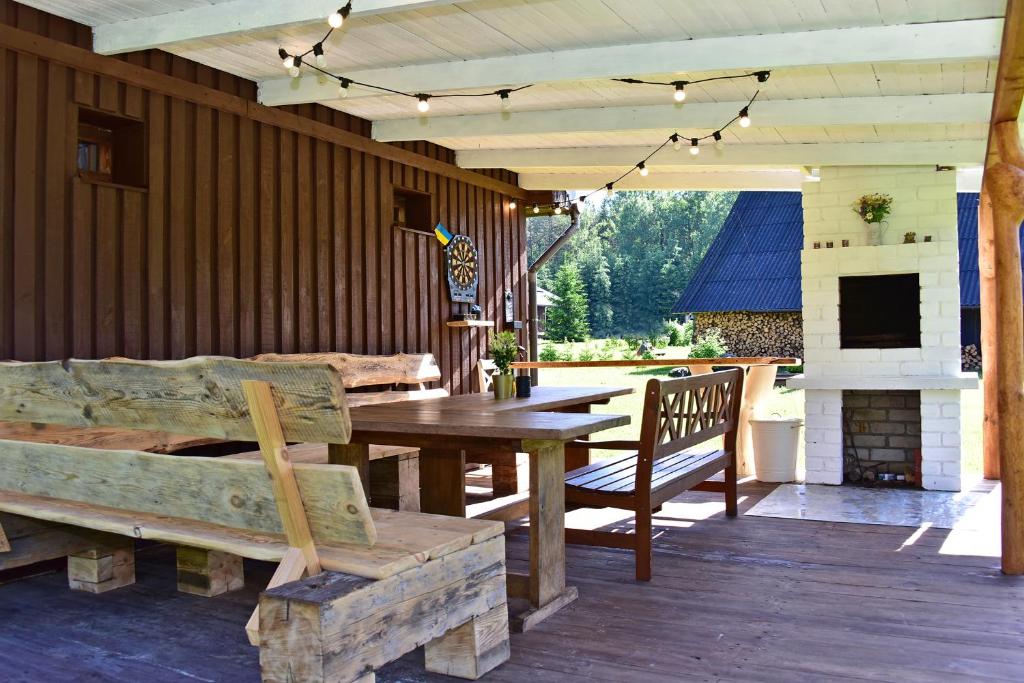 a patio with a wooden table and a fireplace at Pundeliškių sodyba in Skynimai