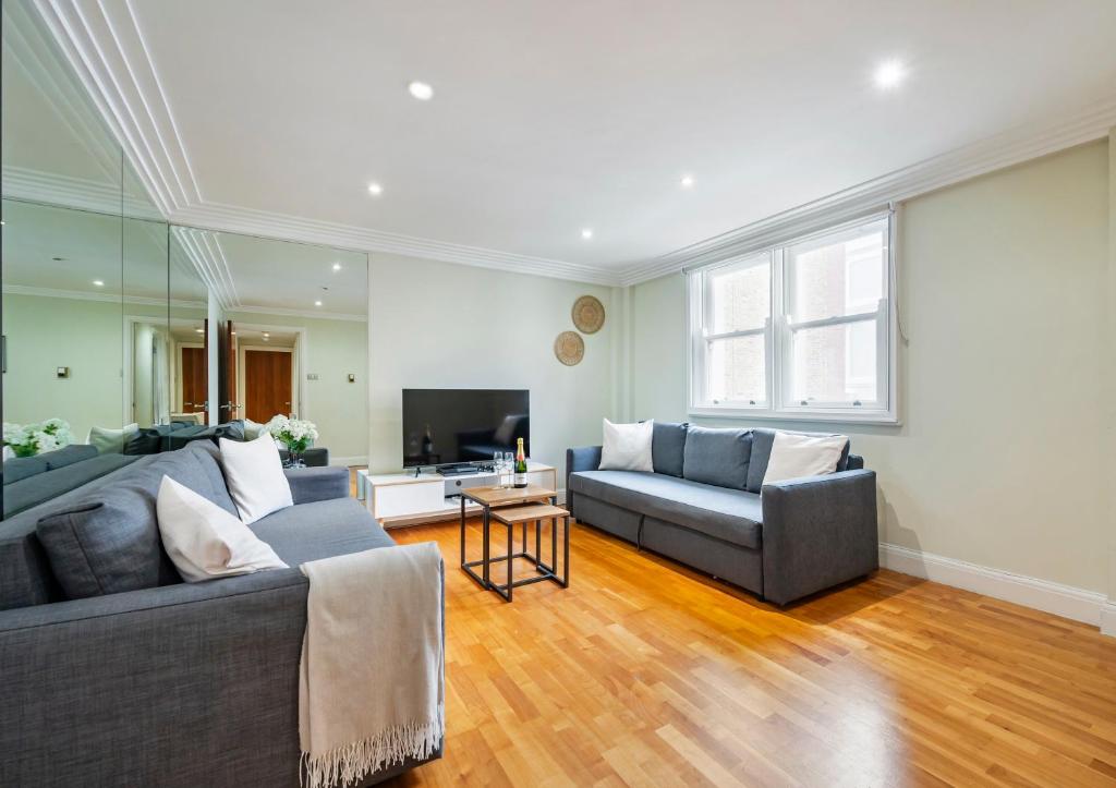 a living room with two couches and a television at Location Trafalgar Square 1 Bedr, 3 Beds, sleeps 6 in London