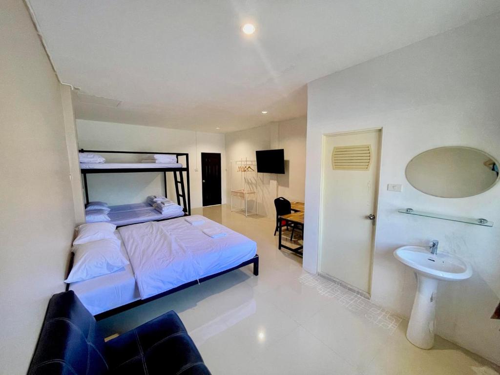 a bedroom with a bed and a sink and a mirror at Lamoon 90s in Hat Yai