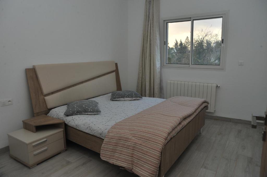 a bedroom with a bed and a window at KANTAOUI RESIDENCE REMY in Hammam Sousse