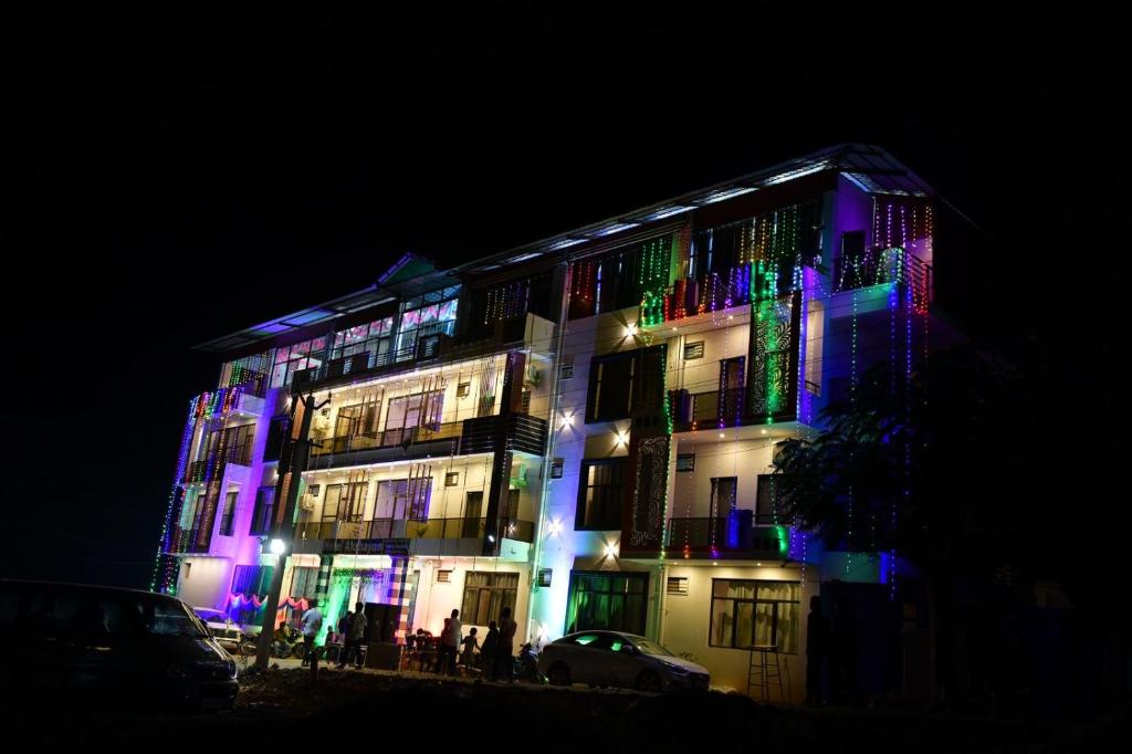 ein Gebäude mit farbenfroher Beleuchtung in der Nacht in der Unterkunft HOTEL AKSHAYAM GRAND INN in Yelagiri