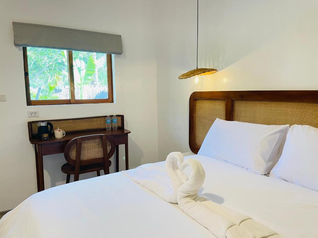 1 dormitorio con 1 cama con sábanas blancas y ventana en MAAYONG HOSTEL en Moalboal
