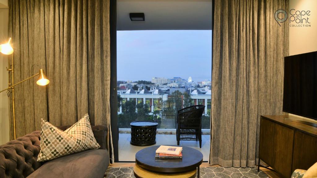 un salon avec un canapé et une grande fenêtre dans l'établissement Luxury apartments - Greenpoint - 35 on Main, au Cap