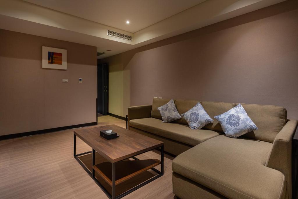 a living room with a couch and a coffee table at Royal Guest Hotel in Tainan