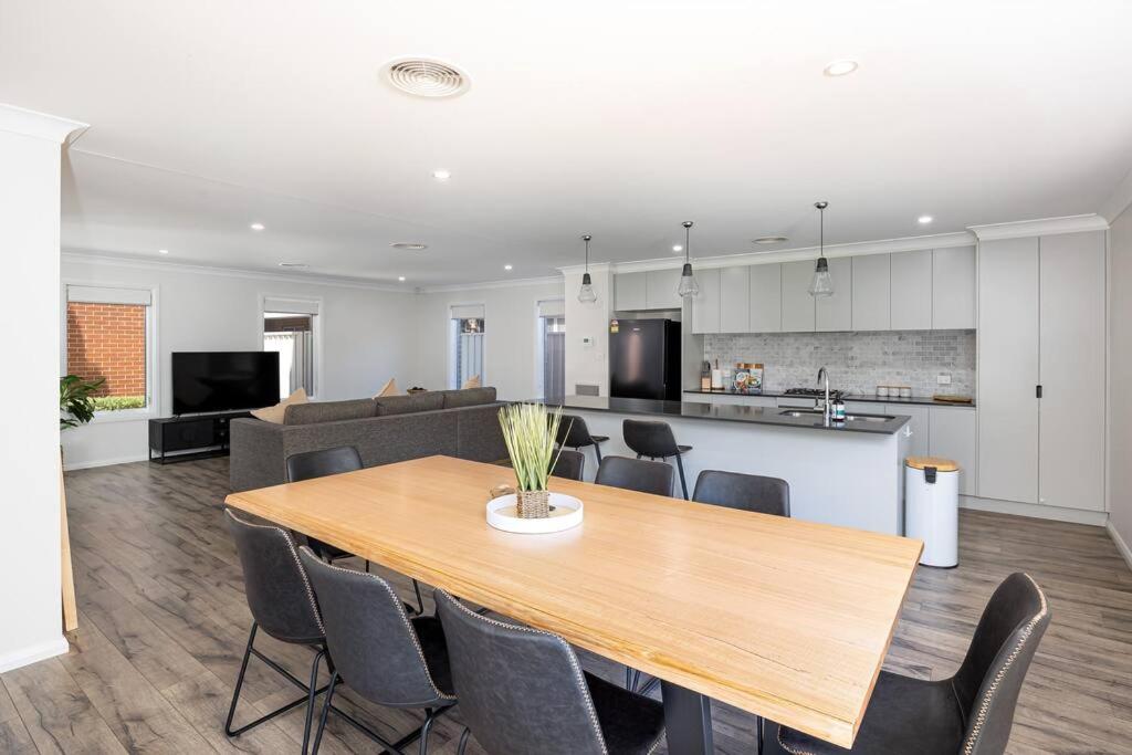 a dining room and kitchen with a table and chairs at Stylish Urban Getaway in the Heart of the City in Wagga Wagga