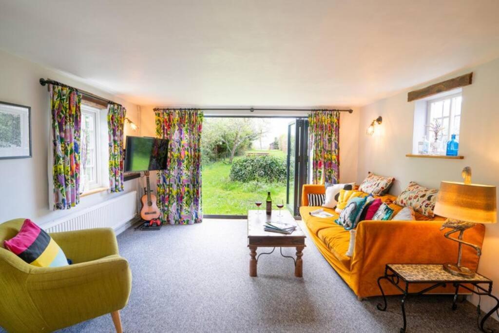 a living room with a yellow couch and two chairs at Prospect Place by UK Vacations in Westleton