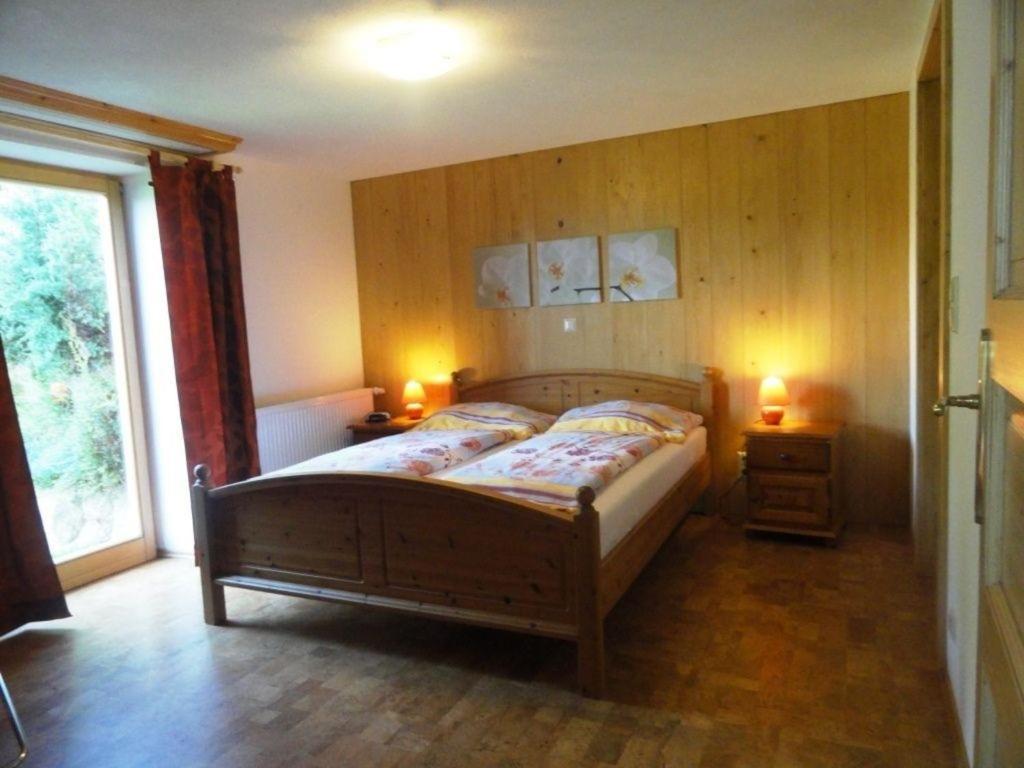 - une chambre avec un lit en bois et une fenêtre dans l'établissement Ferienwohnung für sechs Personen im Erdgeschoss, allergikergeeignet und rollstuhlgerecht, à Millstatt