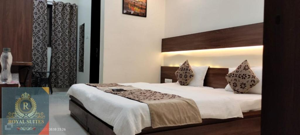 a bedroom with a large bed with white sheets at Royal Suites in Pune