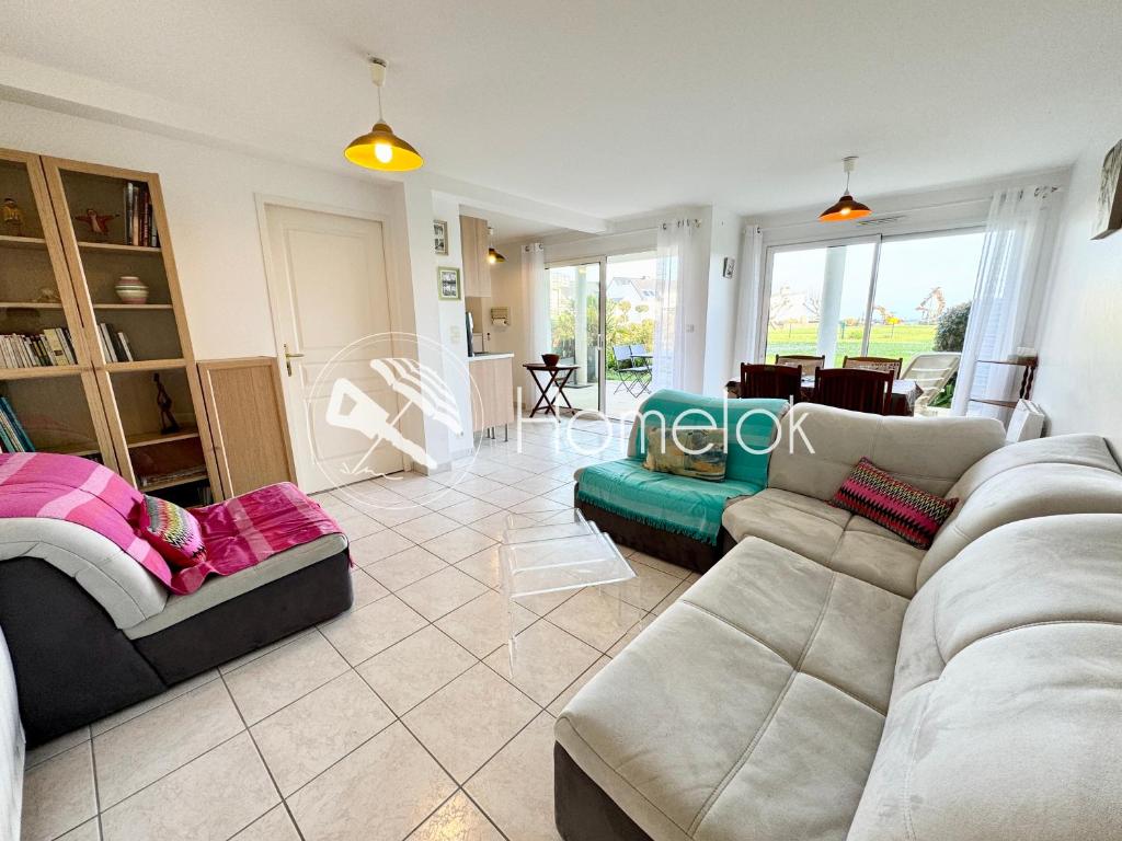 sala de estar con sofá y mesa en Bel appartement face à la mer - Terrasse et jardin, en Larmor-Plage