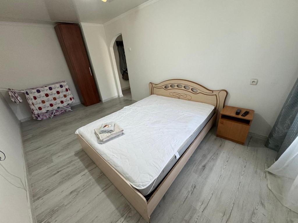 a small bedroom with a bed with white sheets at Сдается уютная 1 комнатная квартира in Astana