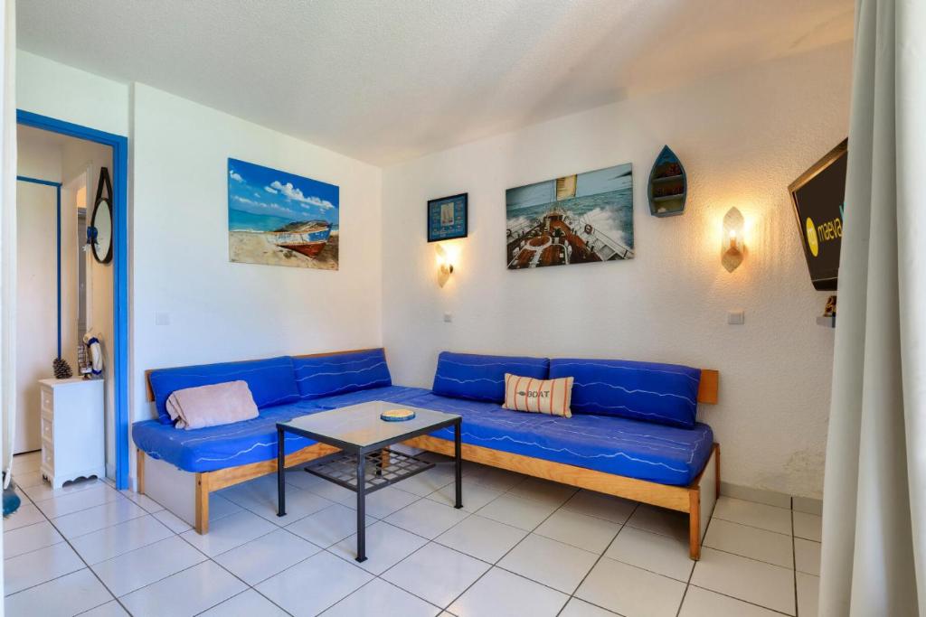 un salon avec un canapé bleu et une table dans l'établissement Résidence Port Bourgenay - maeva Home - Appartement 3 pièces 5 personnes - Sélection MAE-9191, à Talmont-Saint-Hilaire
