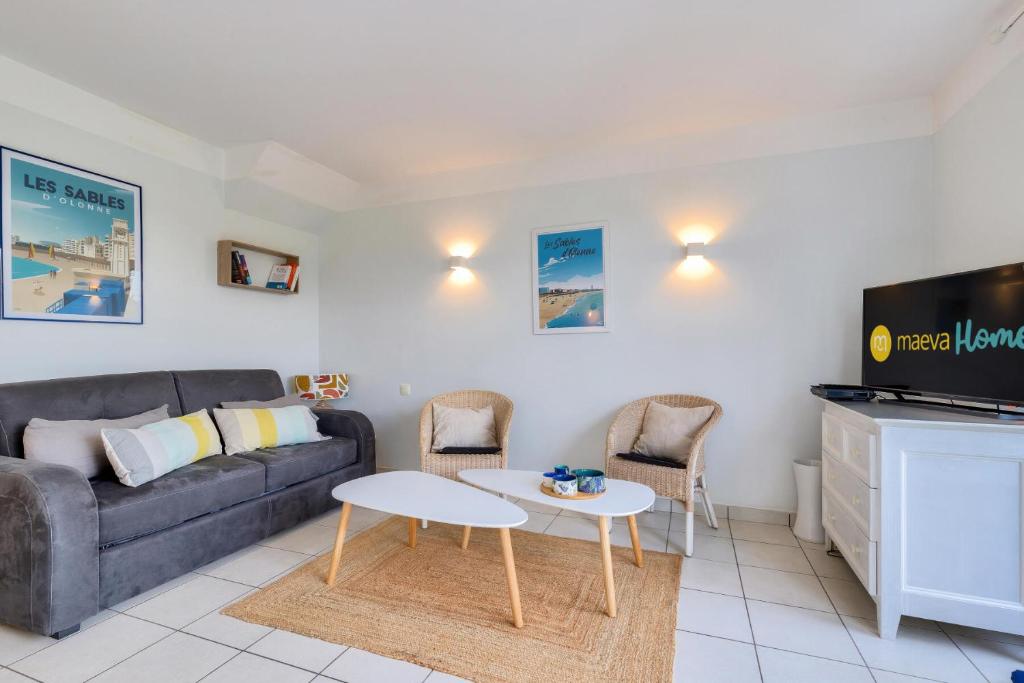 een woonkamer met een bank en een tafel bij Les Maisons de Port Bourgenay - maeva Home - Maison 4 pièces 8 personnes - 291 in Talmont