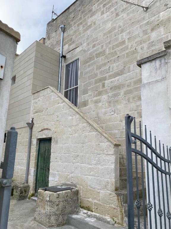 un edificio de ladrillo con escalera y ventana en THE OLD HOUSE 1926, en Uggiano la Chiesa