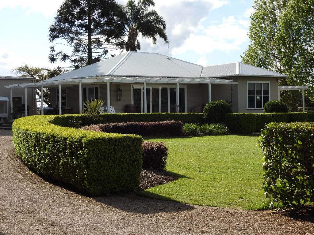 a white house with bushes in front of it at Vue de Lumieres in Maleny