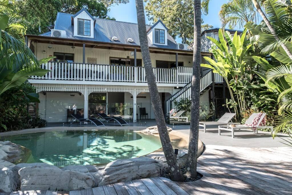 a house with a swimming pool in front of it at The Rest Family Cottage with Resort Style Pool in Noosa Heads