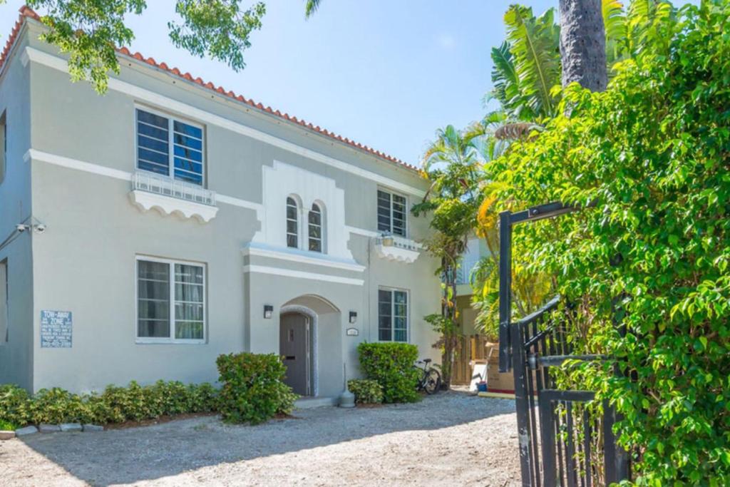 una casa blanca con una puerta delante de ella en L'Etoile Apartments Part of the Oasis Casita Collection, en Miami Beach