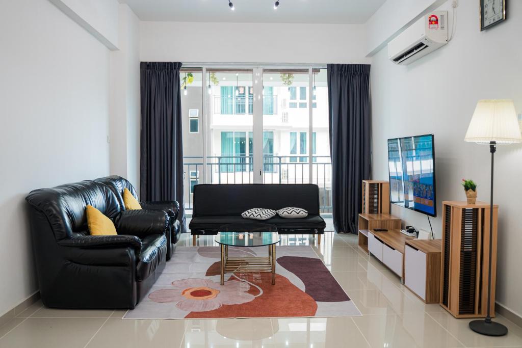 サンダカンにあるTrival Broadway Hut Homestay Sri Indah, Sandakanのリビングルーム(黒い革張りのソファ、ガラステーブル付)