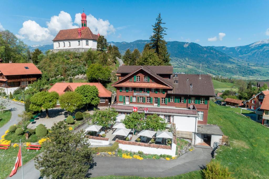 a house on a hill with a lighthouse in the background at Gasthaus Paxmontana in Sachseln