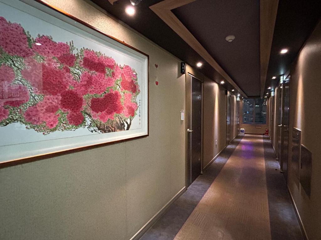 un pasillo con una pintura de flores en la pared en Vision motel en Geoje 