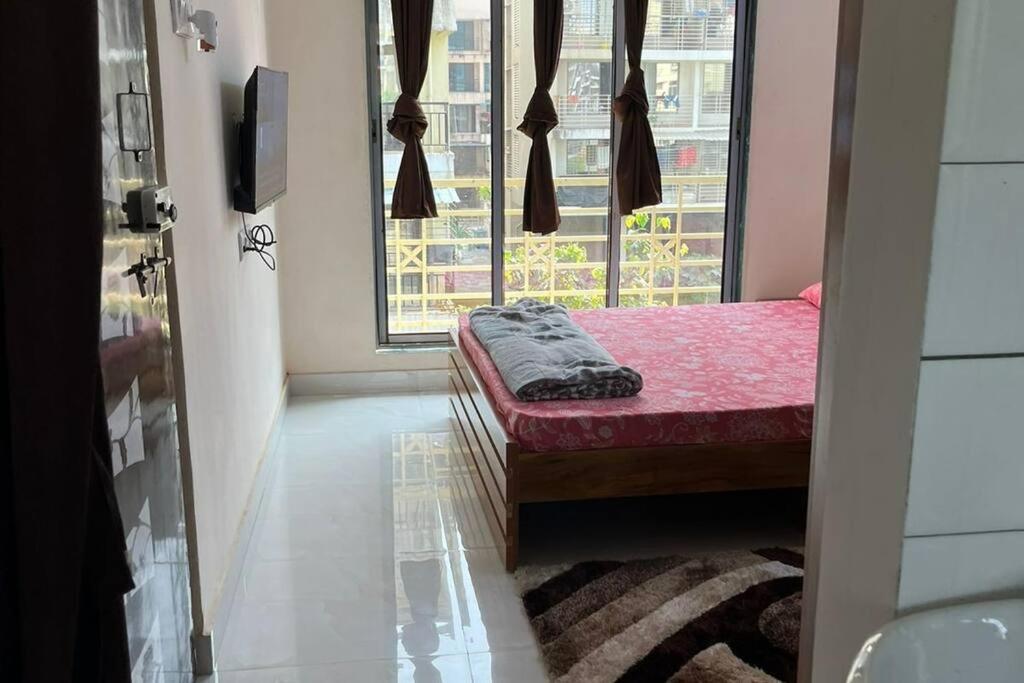 Habitación pequeña con cama y ventana en La Residence en Navi Mumbai