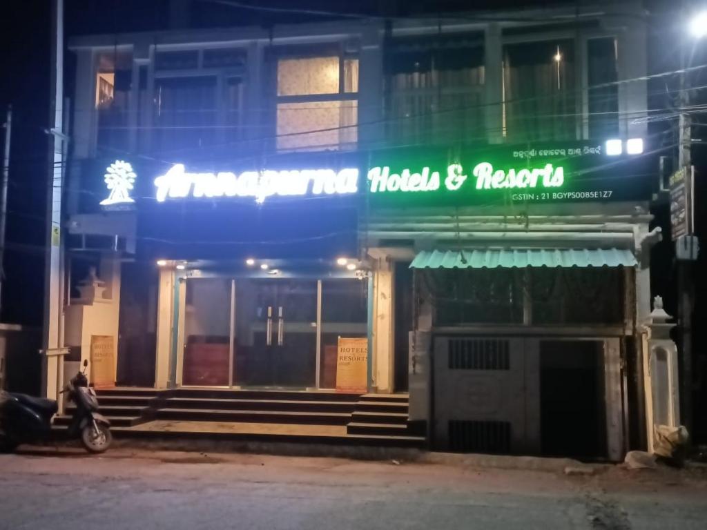 a man sitting on a scooter in front of a building at Arnnapurna Hotel & Resort in Jājpur