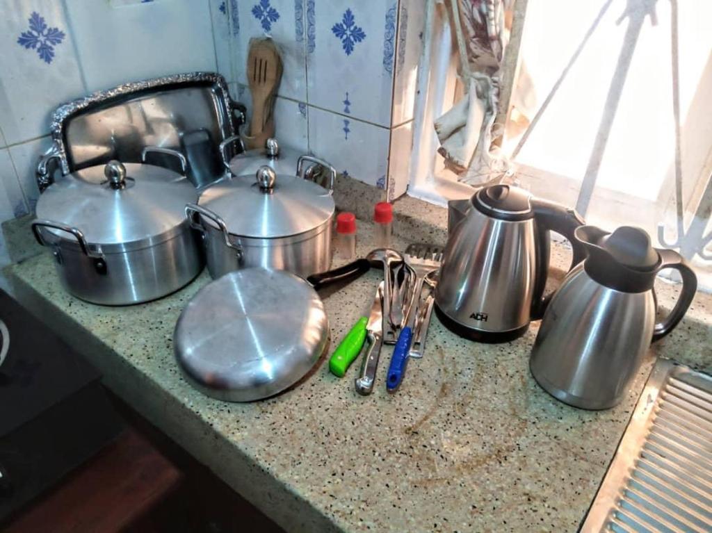 three pots and pans sitting on a kitchen counter at Kabale town flat in Kabale