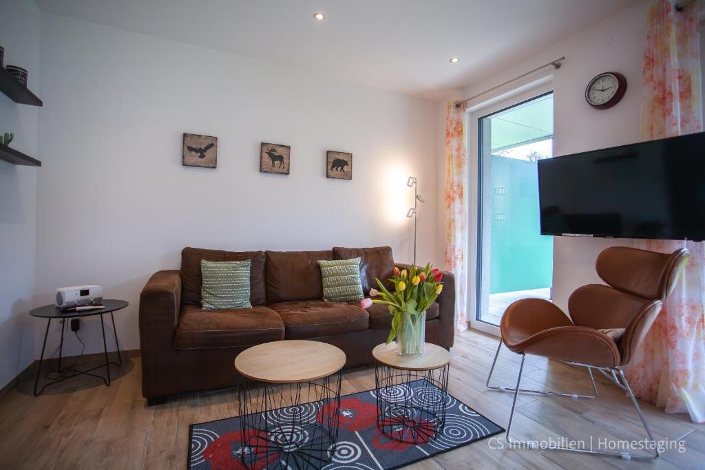 - un salon avec un canapé brun et une télévision dans l'établissement Lago Rosso, à Langenargen