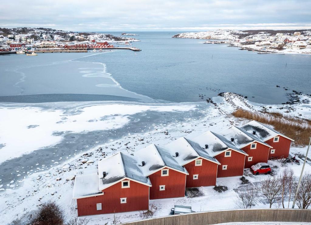 a row of red houses in the snow next to the water at Hönö Sjöbodar in Hönö