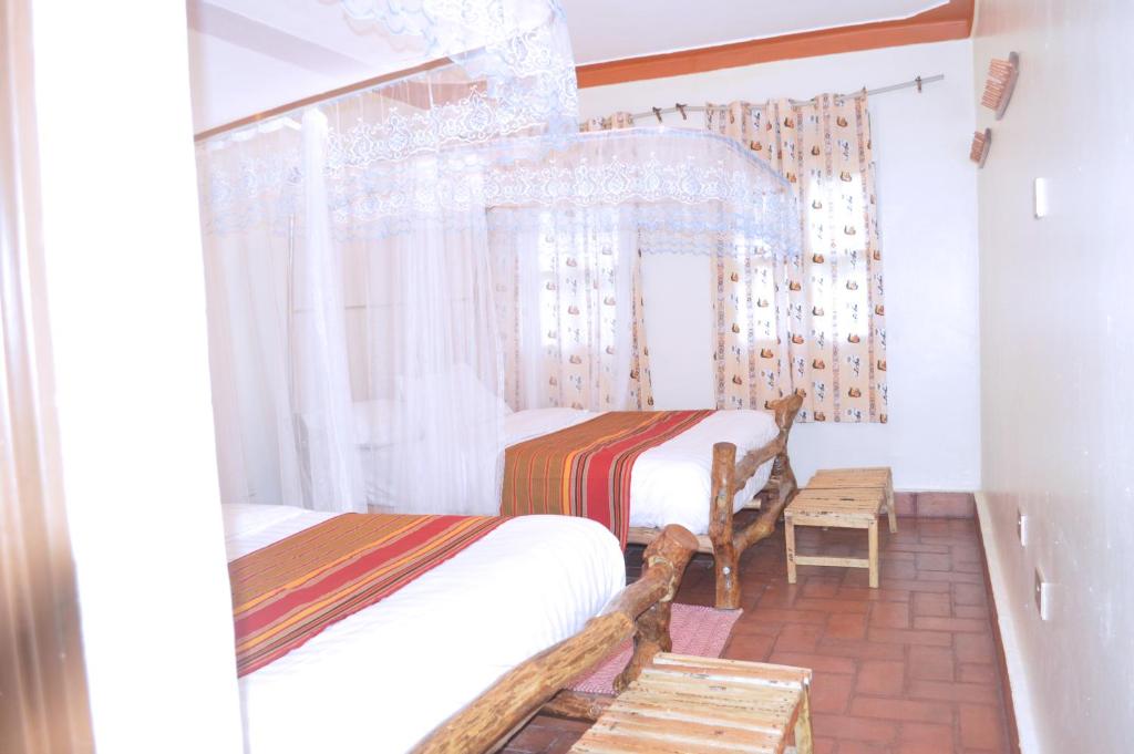 a bedroom with two beds and a window at Kabalega Diner Limited in Nalakonge