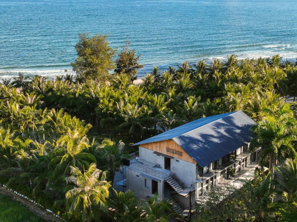 z góry widok na dom z palmami i ocean w obiekcie Anyu Hotel Sanya w mieście Sanya