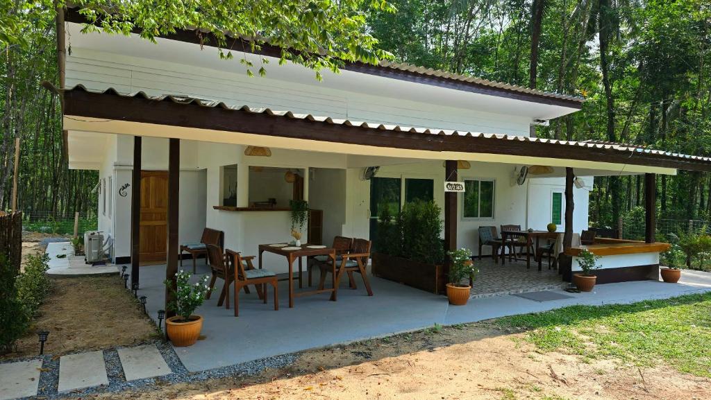 a small white house with a table and chairs at Gecko House Koh Kood in Ban Bang Bao