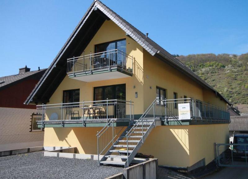 a yellow building with stairs and balconies on it at Ferienweingut Ulrich Göbel in Ernst