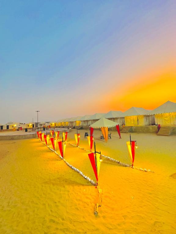 a row of kites on a beach at sunset at Golden Heaven Desert Camp in Jaisalmer